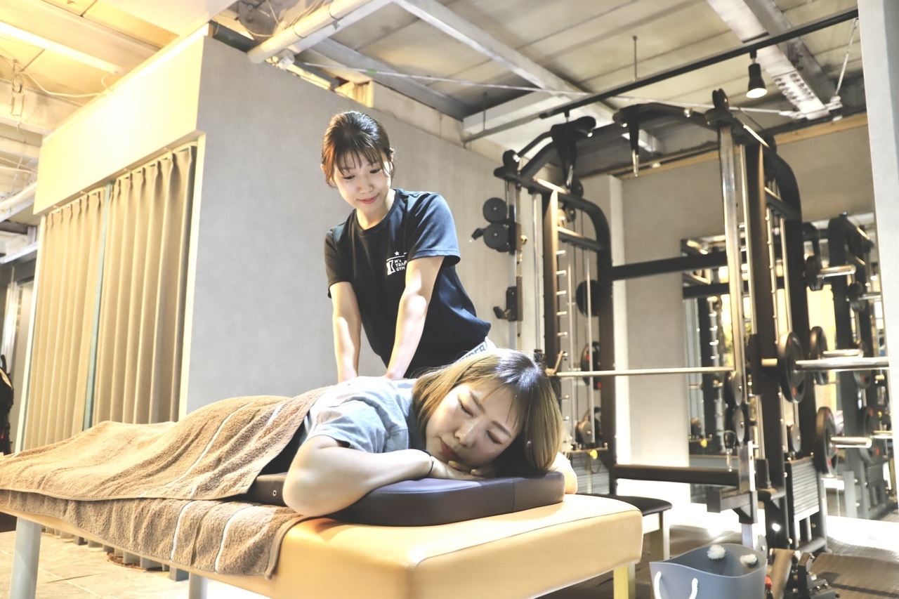 大阪にある女性専用パーソナルジムのエムズトレーニングジム堺市堺東の内装と女性トレーナーが施術している画像